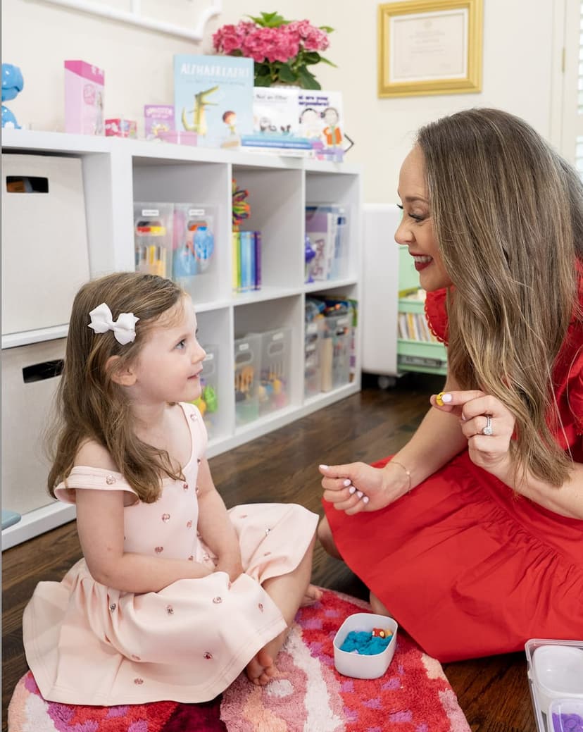 Laura Friedman in a speech therapy session with a school-age client, both smiling
